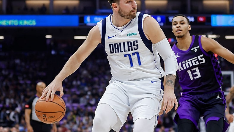Mar 26, 2024; Sacramento, California, USA; Dallas Mavericks guard Luka Doncic (77) passes the ball against Sacramento Kings forward Keegan Murray (13) during the first quarter at Golden 1 Center. Mandatory Credit: Sergio Estrada-USA TODAY Sports