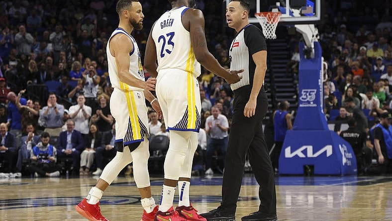 Mar 27, 2024; Orlando, Florida, USA;  Golden State Warriors forward Draymond Green (23) talks to referee Ray Acosta (54) after receiving a foul in the first quarter at the Kia Center. Mandatory Credit: Nathan Ray Seebeck-USA TODAY Sports
