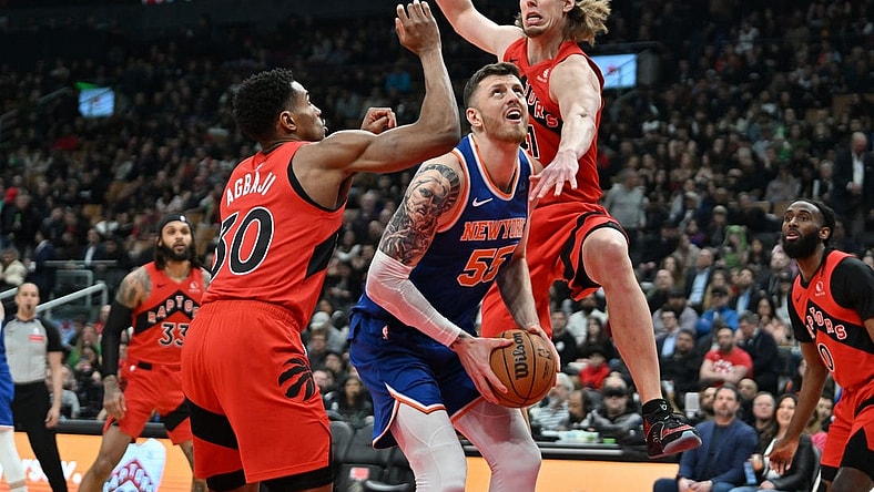Mar 27, 2024; Toronto, Ontario, CAN; New York Knicks center Isaiah Hartenstein (55) drives against Toronto Raptors forward Kelly Olynyk (41) and guard Ochai Agbaji (30) in the first half at Scotiabank Arena. Mandatory Credit: Dan Hamilton-USA TODAY Sports