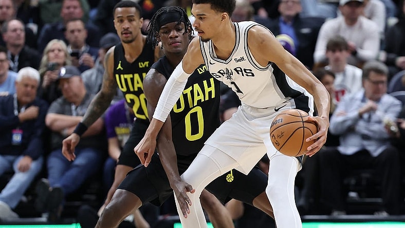Mar 27, 2024; Salt Lake City, Utah, USA; San Antonio Spurs center Victor Wembanyama (1) moves the ball away from Utah Jazz forward Taylor Hendricks (0) during the second quarter at Delta Center. Mandatory Credit: Rob Gray-USA TODAY Sports