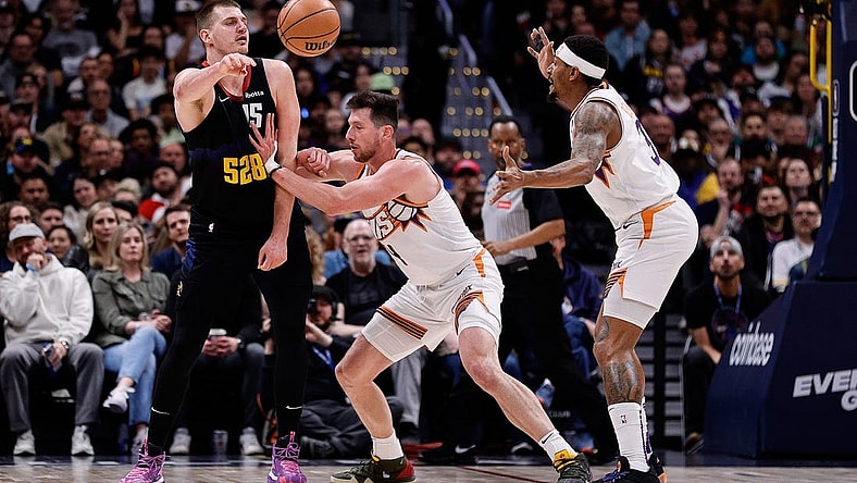Mar 27, 2024; Denver, Colorado, USA; Denver Nuggets center Nikola Jokic (15) passes the ball against Phoenix Suns forward Drew Eubanks (14) and guard Bradley Beal (3) in the third quarter at Ball Arena. Mandatory Credit: Isaiah J. Downing-USA TODAY Sports