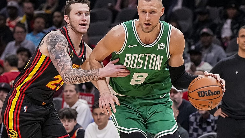 Mar 28, 2024; Atlanta, Georgia, USA; Boston Celtics center Kristaps Porzingis (8) dribbles against Atlanta Hawks guard Garrison Mathews (25) during the first half at State Farm Arena. Mandatory Credit: Dale Zanine-USA TODAY Sports