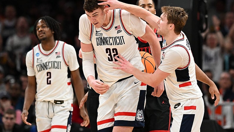 Mar 28, 2024; Boston, MA, USA; Connecticut Huskies guard Cam Spencer (12) reacts with center Donovan Clingan (32) in the semifinals of the East Regional of the 2024 NCAA Tournament at TD Garden. Mandatory Credit: Brian Fluharty-USA TODAY Sports