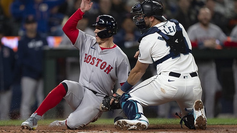 Mar 28, 2024; Seattle, Washington, USA; Boston Red Sox right fielder Tyler O'Neill (17) scores a run after a throw gets past Seattle Mariners catcher Cal Raleigh (29) during the fourth inning at T-Mobile Park. Mandatory Credit: Stephen Brashear-USA TODAY Sports