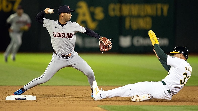 Mar 28, 2024; Oakland, California, USA; Cleveland Guardians shortstop Brayan Rocchio (4) throws over Oakland Athletics center fielder JJ Bleday (33) to complete a double play during the fourth inning at Oakland-Alameda County Coliseum. Seth Brown was out at first base. Mandatory Credit: D. Ross Cameron-USA TODAY Sports
