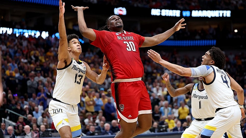 Mar 29, 2024; Dallas, TX, USA; North Carolina State Wolfpack forward DJ Burns Jr. (30) rebounds against Marquette Golden Eagles forward Oso Ighodaro (13),  guard Kam Jones (1) and guard Stevie Mitchell (4) during the second half in the semifinals of the South Regional of the 2024 NCAA Tournament at American Airlines Center. Mandatory Credit: Kevin Jairaj-USA TODAY Sports