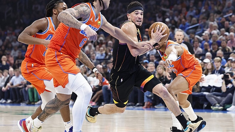 Mar 29, 2024; Oklahoma City, Oklahoma, USA; Phoenix Suns guard Devin Booker (1) drives to the basket between Oklahoma City Thunder guard Aaron Wiggins (21) and forward Jaylin Williams (6) during the first half at Paycom Center. Mandatory Credit: Alonzo Adams-USA TODAY Sports