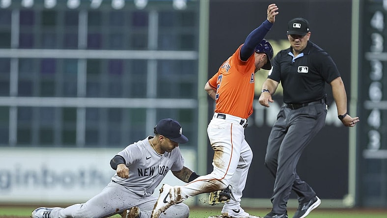 Mar 29, 2024; Houston, Texas, USA; Houston Astros third baseman Alex Bregman (2) is safe at second base as New York Yankees second baseman Gleyber Torres (25) attempts to apply a tag during the third inning at Minute Maid Park. Mandatory Credit: Troy Taormina-USA TODAY Sports
