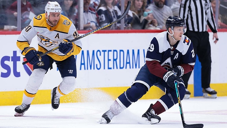 Mar 30, 2024; Denver, Colorado, USA; Colorado Avalanche center Nathan MacKinnon (29) skates with the puck against Nashville Predators center Ryan O'Reilly (90) during the first period at Ball Arena. Mandatory Credit: Andrew Wevers-USA TODAY Sports