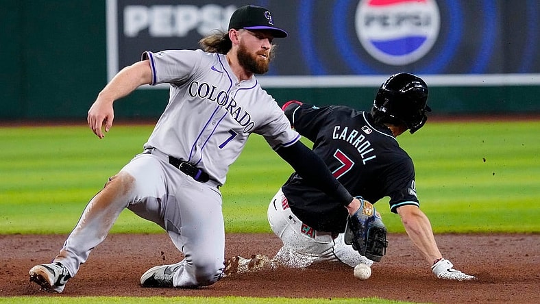Rockies Brendan Rodgers (7) drops the ball before applying a late tag to Diamondbacks Corbin Carroll (7) as he slides safely into second for a steal during a game at Chase Field.