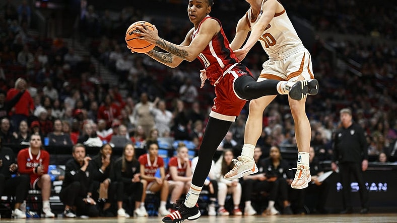 Mar 31, 2024; Portland, OR, USA; NC State Wolfpack guard Aziaha James (10) grabs a rebound during the first half against Texas Longhorns guard Shay Holle (10) in the finals of the Portland Regional of the NCAA Tournament at the Moda Center center. Mandatory Credit: Troy Wayrynen-USA TODAY Sports