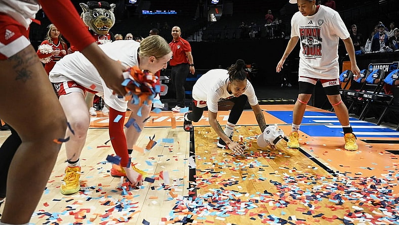 Mar 31, 2024; Portland, OR, USA; NC State Wolfpack guard Aziaha James (10) slides in confetti with teammates, forward Maddie Cox (11) and guard Zoe Brooks (35) in celebration after a game against the Texas Longhorns in the finals of the Portland Regional of the NCAA Tournament at the Moda Center center. Mandatory Credit: Troy Wayrynen-USA TODAY Sports