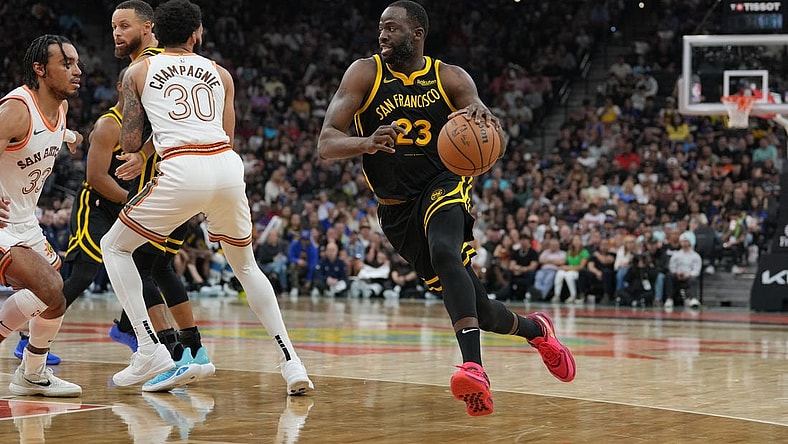 Mar 31, 2024; San Antonio, Texas, USA;  Golden State Warriors forward Draymond Green (23) dribbles past San Antonio Spurs forward Julian Champagnie (30) in the first half at Frost Bank Center. Mandatory Credit: Daniel Dunn-USA TODAY Sports