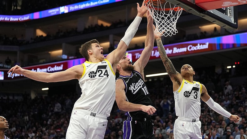 Mar 31, 2024; Sacramento, California, USA; Sacramento Kings forward Domantas Sabonis (10) shoots against Utah Jazz center Walker Kessler (24) and guard Keyonte George (3) during the second quarter at Golden 1 Center. Mandatory Credit: Darren Yamashita-USA TODAY Sports