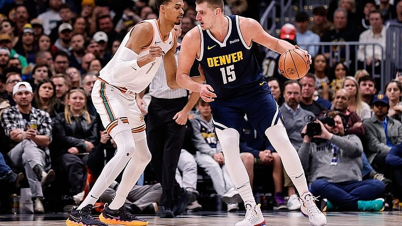 Nov 26, 2023; Denver, Colorado, USA; Denver Nuggets center Nikola Jokic (15) controls the ball as San Antonio Spurs center Victor Wembanyama (1) guards in the third quarter at Ball Arena. Mandatory Credit: Isaiah J. Downing-USA TODAY Sports