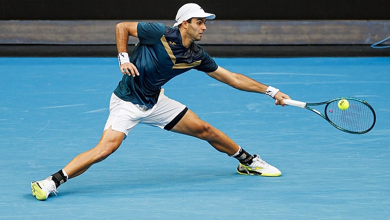 Jan 14, 2024; Melbourne, Victoria, Australia;  Facundo Diaz Acosta of Argentina hits a shot against Taylor Fritz of the United States in the first round of the men s singles. Mandatory Credit: Mike Frey-USA TODAY Sports