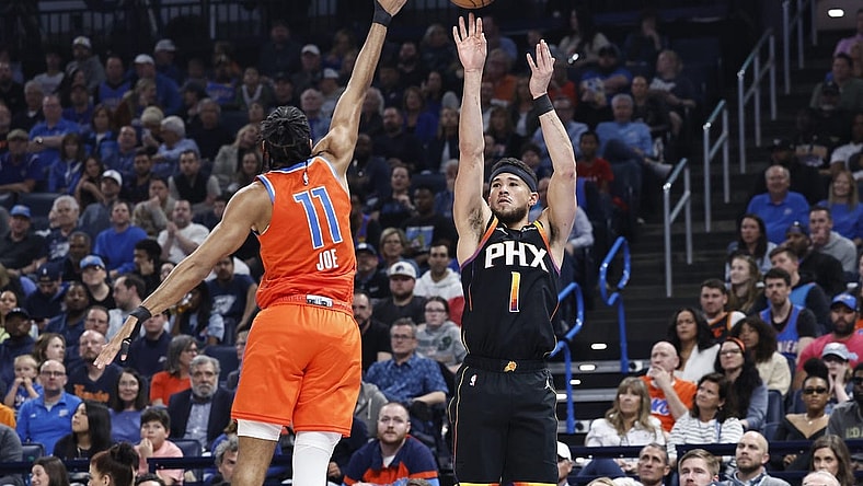 Mar 29, 2024; Oklahoma City, Oklahoma, USA; Phoenix Suns guard Devin Booker (1) shoots a three-point basket as Oklahoma City Thunder guard Isaiah Joe (11) defends during the first half at Paycom Center. Mandatory Credit: Alonzo Adams-USA TODAY Sports