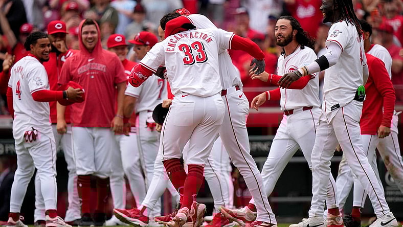 Cincinnati Reds center fielder Will Benson (30) embraces Cincinnati Reds first baseman Christian Encarnacion-Strand (33) after he hit a walk-off home run in the ninth inning of a baseball game against the Washington Nationals, Sunday, March 31, 2024, at Great American Ball Park in Cincinnati.