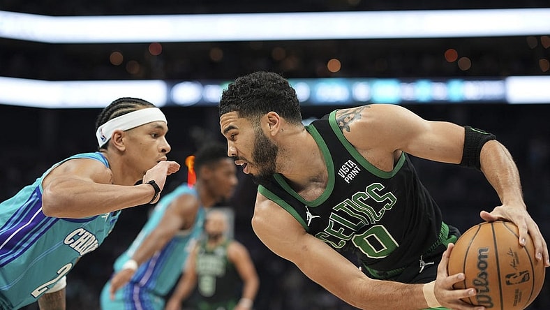 Apr 1, 2024; Charlotte, North Carolina, USA; Boston Celtics forward Jayson Tatum (0) handles the ball against Charlotte Hornets guard Tre Mann (23) during the first quarter at Spectrum Center. Mandatory Credit: Jim Dedmon-USA TODAY Sports