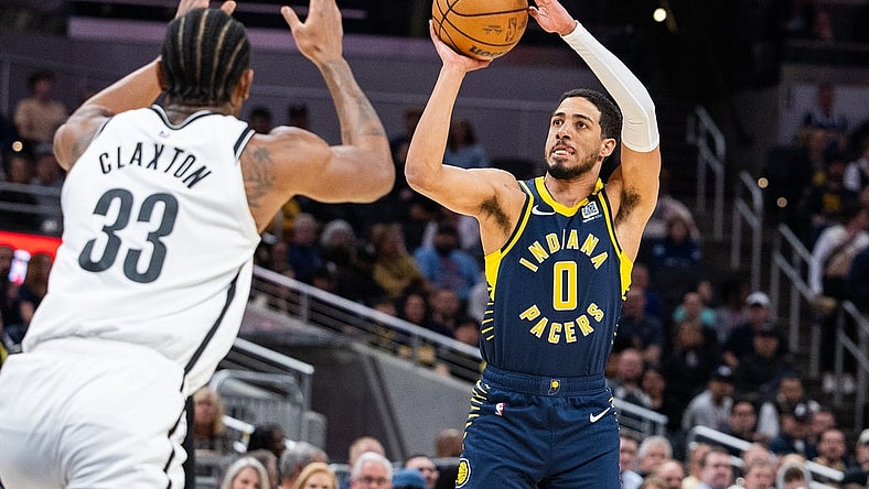 Apr 1, 2024; Indianapolis, Indiana, USA; Indiana Pacers guard Tyrese Haliburton (0) shoots the ball while Brooklyn Nets center Nic Claxton (33) defends in the first half at Gainbridge Fieldhouse. Mandatory Credit: Trevor Ruszkowski-USA TODAY Sports