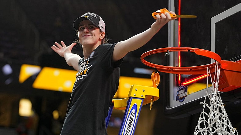 Apr 1, 2024; Albany, NY, USA; Iowa Hawkeyes guard Caitlin Clark (22) cuts the net after defeating the LSU Lady Tigers in the finals of the Albany Regional in the 2024 NCAA Tournament at MVP Arena. Mandatory Credit: Gregory Fisher-USA TODAY Sports