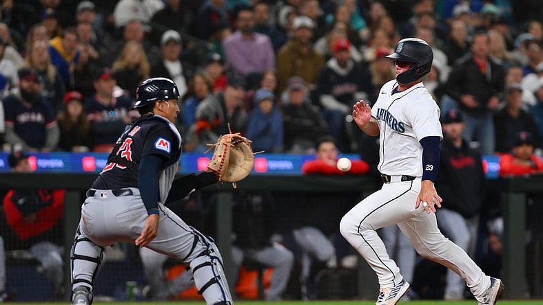 Apr 1, 2024; Seattle, Washington, USA; Cleveland Guardians catcher Bo Naylor (23) catches the ball and later tags out Seattle Mariners first baseman Ty France (23) at home plate during the fourth inning at T-Mobile Park. Mandatory Credit: Steven Bisig-USA TODAY Sports
