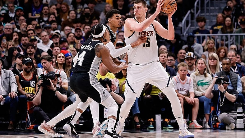 Apr 2, 2024; Denver, Colorado, USA; Denver Nuggets center Nikola Jokic (15) controls the ball as San Antonio Spurs center Victor Wembanyama (1) and guard Devonte' Graham (4) defend in the second quarter at Ball Arena. Mandatory Credit: Isaiah J. Downing-USA TODAY Sports