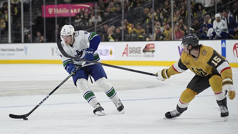 Vancouver Canucks right wing Brock Boeser (6) skates up the ice against Vegas Golden Knights defenseman Noah Hanifin (15) during the third period of an NHL hockey game Tuesday, April 2, 2024, in Las Vegas. (AP Photo/John Locher)