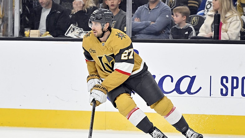 Vegas Golden Knights defenseman Shea Theodore (27) handles the puck against the Calgary Flames during the first period of an NHL hockey game Sunday, Dec. 29, 2024, in Las Vegas. (AP Photo/David Becker)