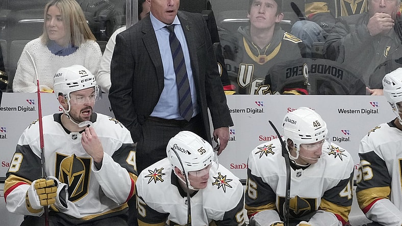 Vegas Golden Knights head coach Bruce Cassidy, standing, reacts from behind players on the bench during the third period of an NHL hockey game against the San Jose Sharks in San Jose, Calif., Tuesday, Jan. 7, 2025. (AP Photo/Jeff Chiu)