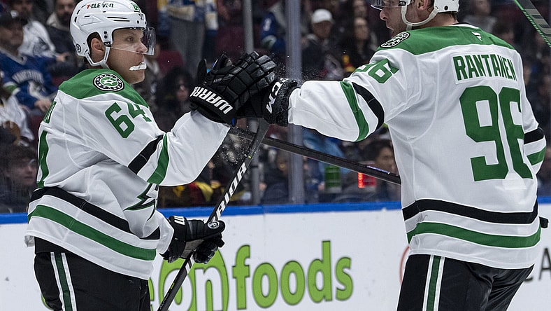 Dallas Stars' Mikael Granlund (64) and Mikko Rantanen (96) celebrate Granlund's goal against the Vancouver Canucks during the second period of an NHL hockey game in Vancouver, British Columbia, Sunday, March 9, 2025. (Ethan Cairns/The Canadian Press via AP)