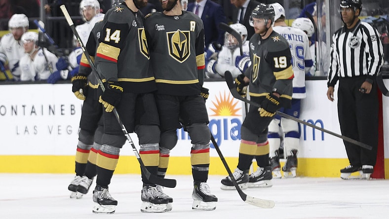 Vegas Golden Knights defensemen Nicolas Hague (14) and Alex Pietrangelo (7) celebrate after Hague's goal during the third period of an NHL hockey game against the Tampa Bay Lightning, Sunday, March 23, 2025, in Las Vegas. (AP Photo/Ian Maule)