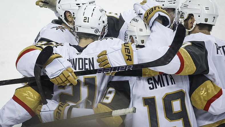 Vegas Golden Knights' Reilly Smith (19) celebrates his game-winning goal with teammates during overtime in an NHL hockey game against the Calgary Flames in Calgary, Alberta, Saturday, April 5, 2025. (Jeff McIntosh/The Canadian Press via AP)