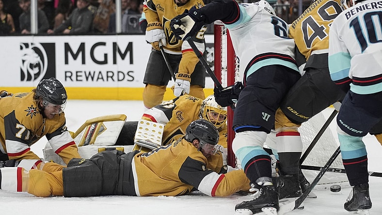 Vegas Golden Knights defenseman Brayden McNabb (3) lies on the ice while battling for th puck against the Seattle Kraken during the third period of an NHL hockey game Thursday, April 10, 2025, in Las Vegas. (AP Photo/John Locher)