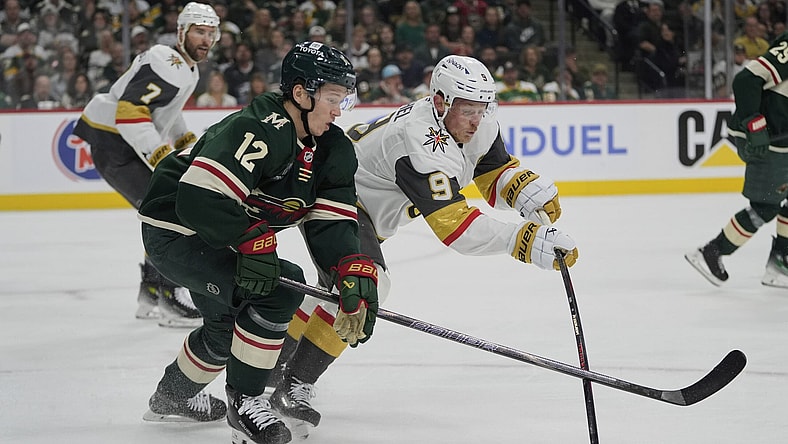 Minnesota Wild left wing Matt Boldy (12) and Vegas Golden Knights center Jack Eichel (9) battle for the puck during the first period of Game 3 of a first-round NHL hockey playoff series Thursday, April 24, 2025, in St. Paul, Minn. (AP Photo/Abbie Parr)
