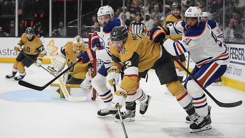 From right, Edmonton Oilers left wing Evander Kane (91), Vegas Golden Knights defenseman Brayden McNabb (3) and Edmonton Oilers center Leon Draisaitl (29) vie for the puck during the first period of Game 1 of a second-round NHL hockey playoff series Tuesday, May 6, 2025, in Las Vegas. (AP Photo/John Locher)