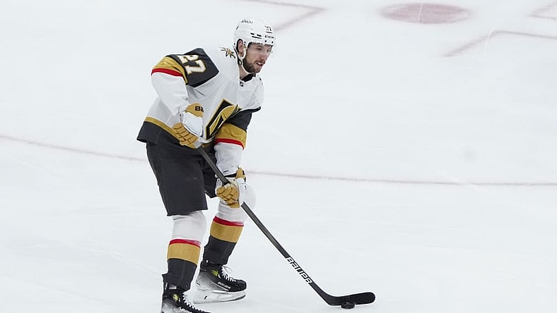 Vegas Golden Knights Defenseman Shea Theodore (27) controls the puck during the first period of the National Hockey League game between the Vegas Golden Knights and the New York Islanders on February 4, 2025, at UBS Arena in Elmont, NY.