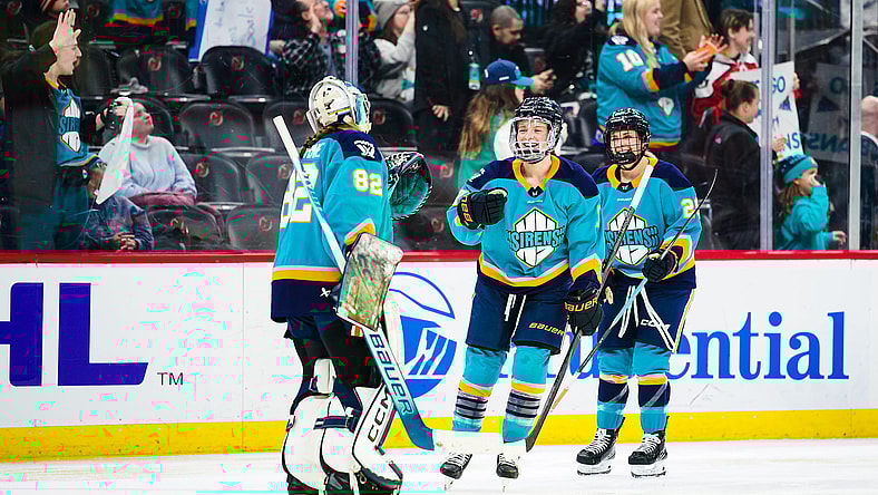 New York Sirens forward Savannah Norcross celebrates a win over the Vancouver Goldeneyes with goalie Kayle Osborne.