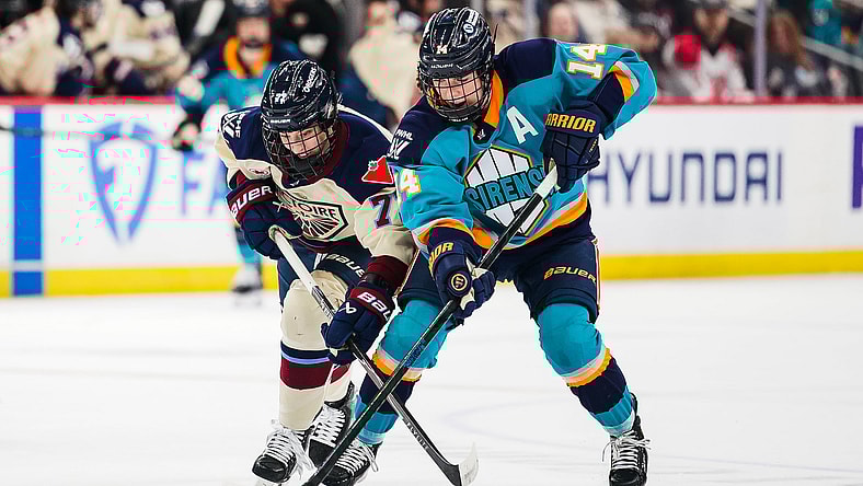 New York Sirens defender Jaime Bourbonnais and Montreal Victoire forward Jade Downie-Landry battle for the puck.