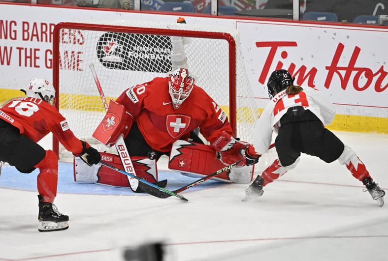 Hockey: IIHF Women's World Championship Hockey. Swiss goalie Andrea Brändli makes a stop on Canadian and New York Sirens forward Kristin O'Neill.