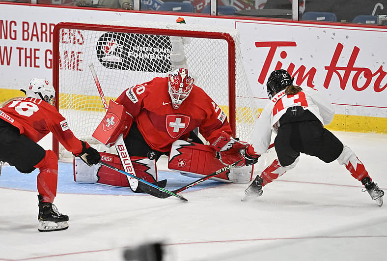 Hockey: IIHF Women's World Championship Hockey. Swiss goalie Andrea Brändli makes a stop on Canadian and New York Sirens forward Kristin O'Neill.