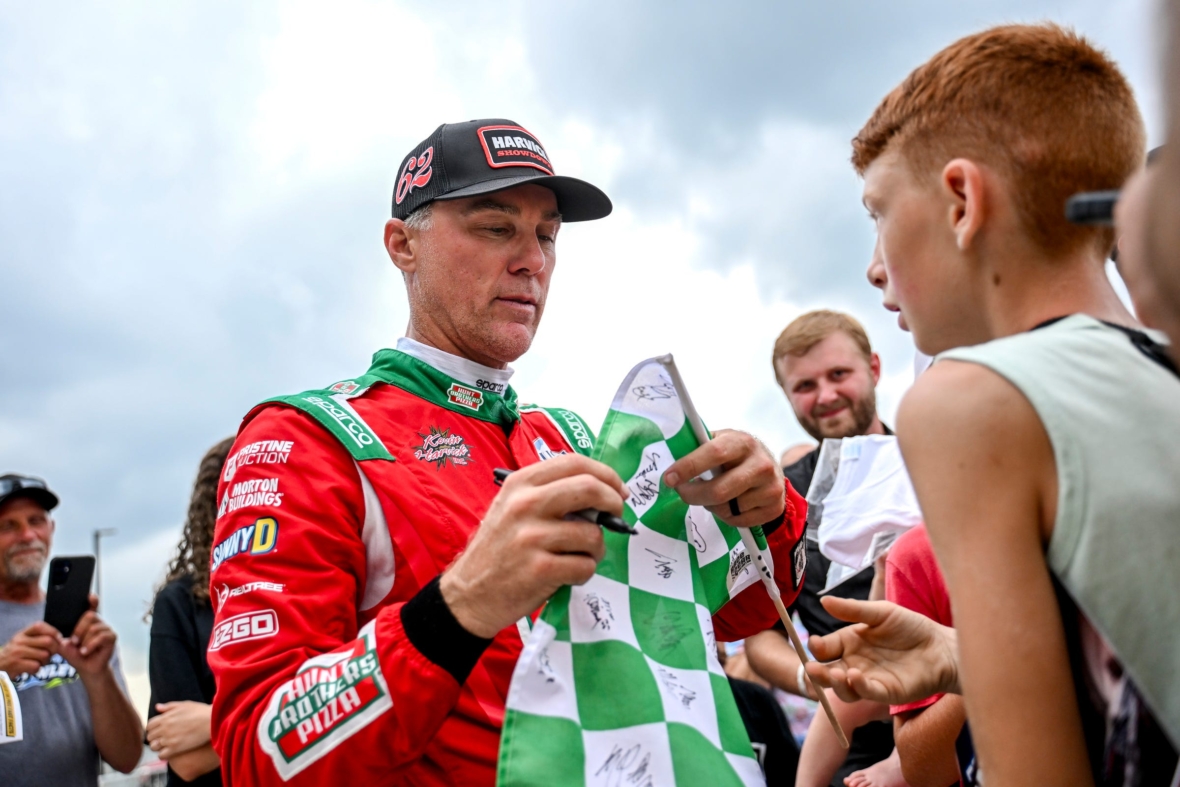 Former NASCAR Cup Series champion Kevin Harvick signs items for fans during an autograph session before the 13th annual Masters Kevin Harvick